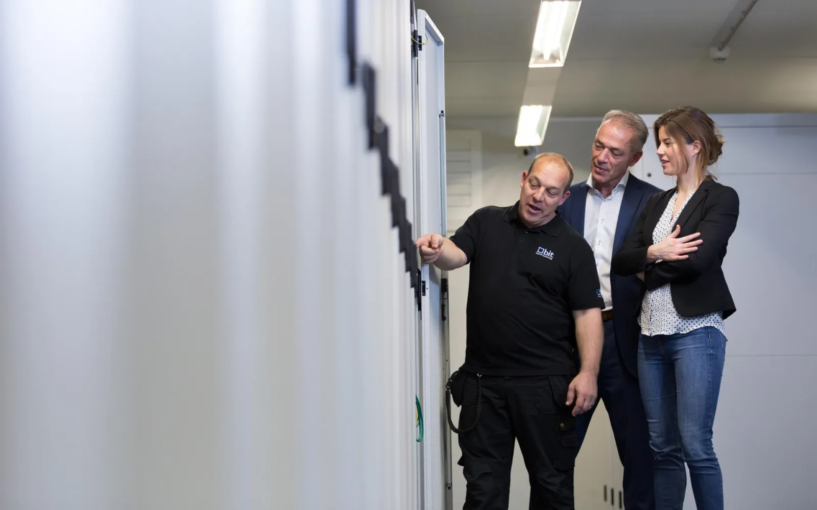 Engineer van BIT geeft bezoekers uitleg bij een serverrack